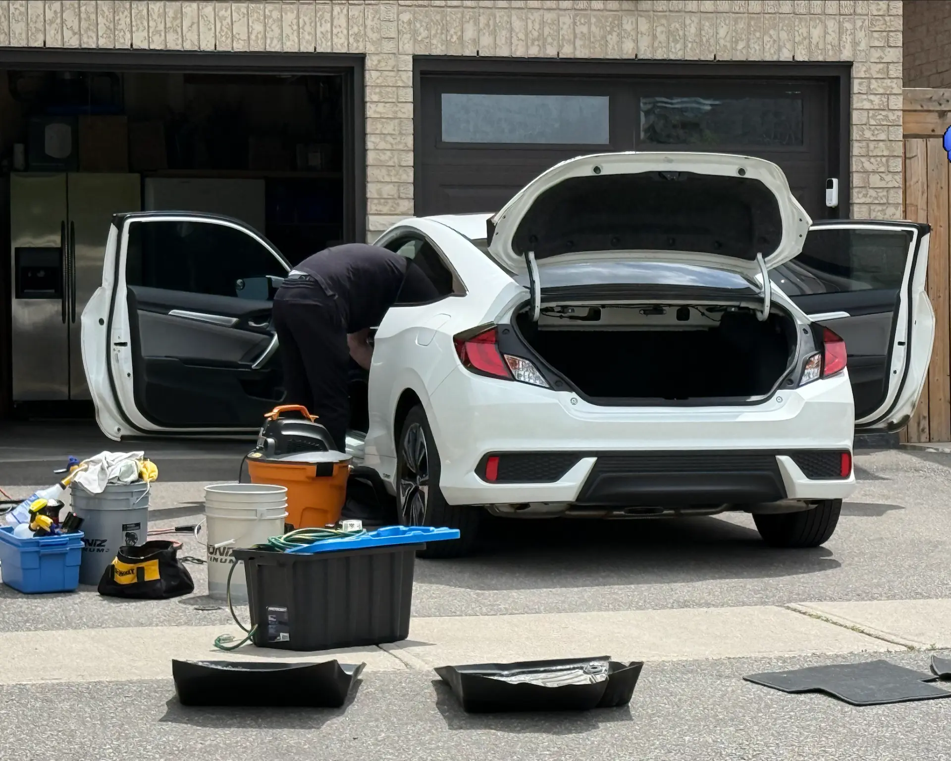 White Civic with doors and trunk open during a full detail in a Milton driveway