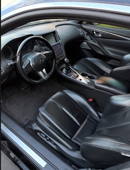 Detailer hand-polishing a glossy red sedan