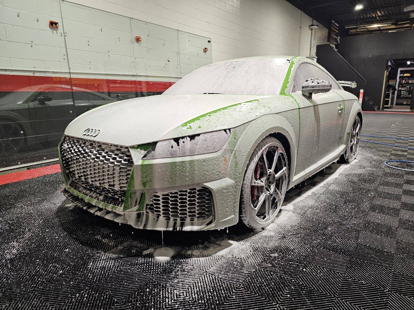 White SUV covered in foam during contact wash