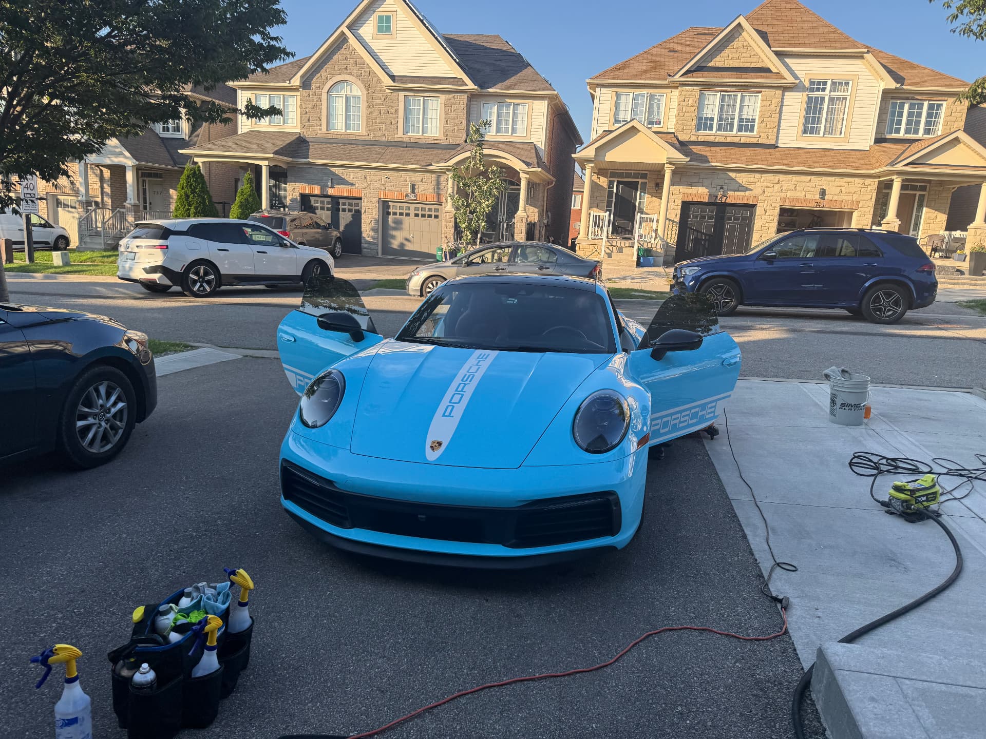 Light blue Porsche 911 with doors open during a Polish & Go mobile detail in a Milton driveway